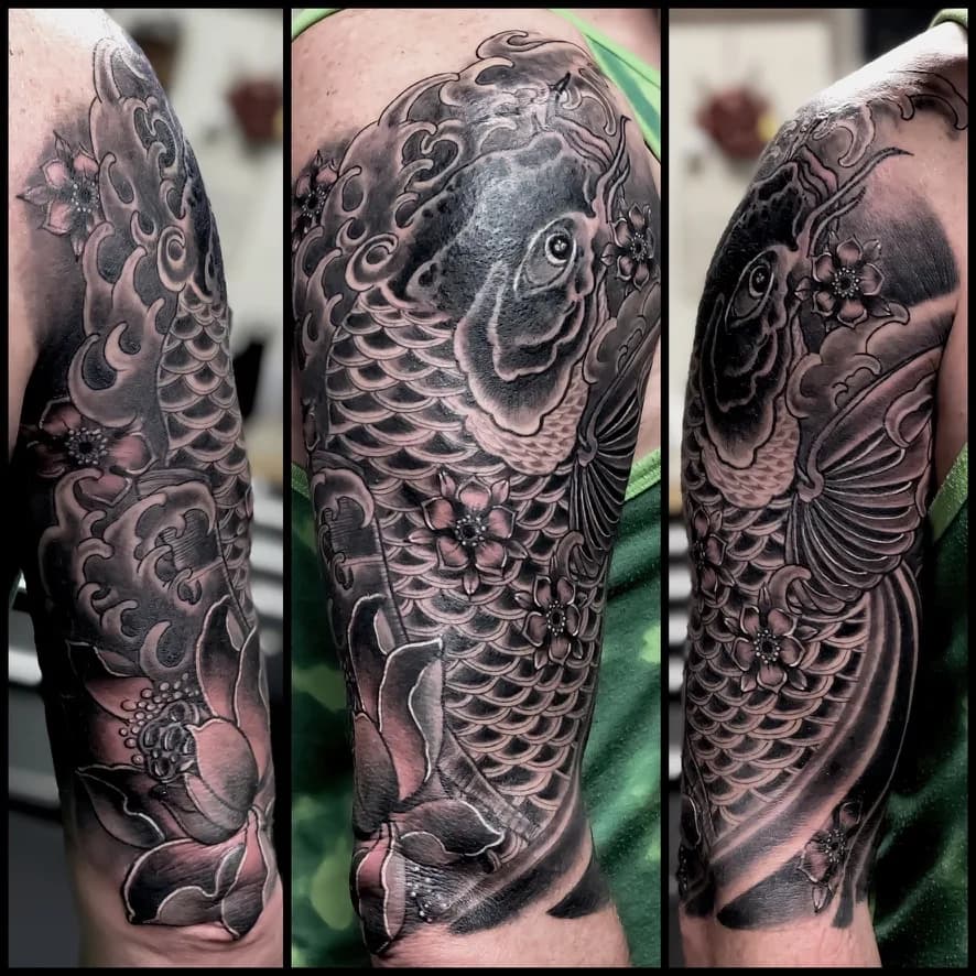 Black and grey Japanese koi half sleeve tattoo with lotus flowers by Nate at Village Tattoo Company in London Ontario