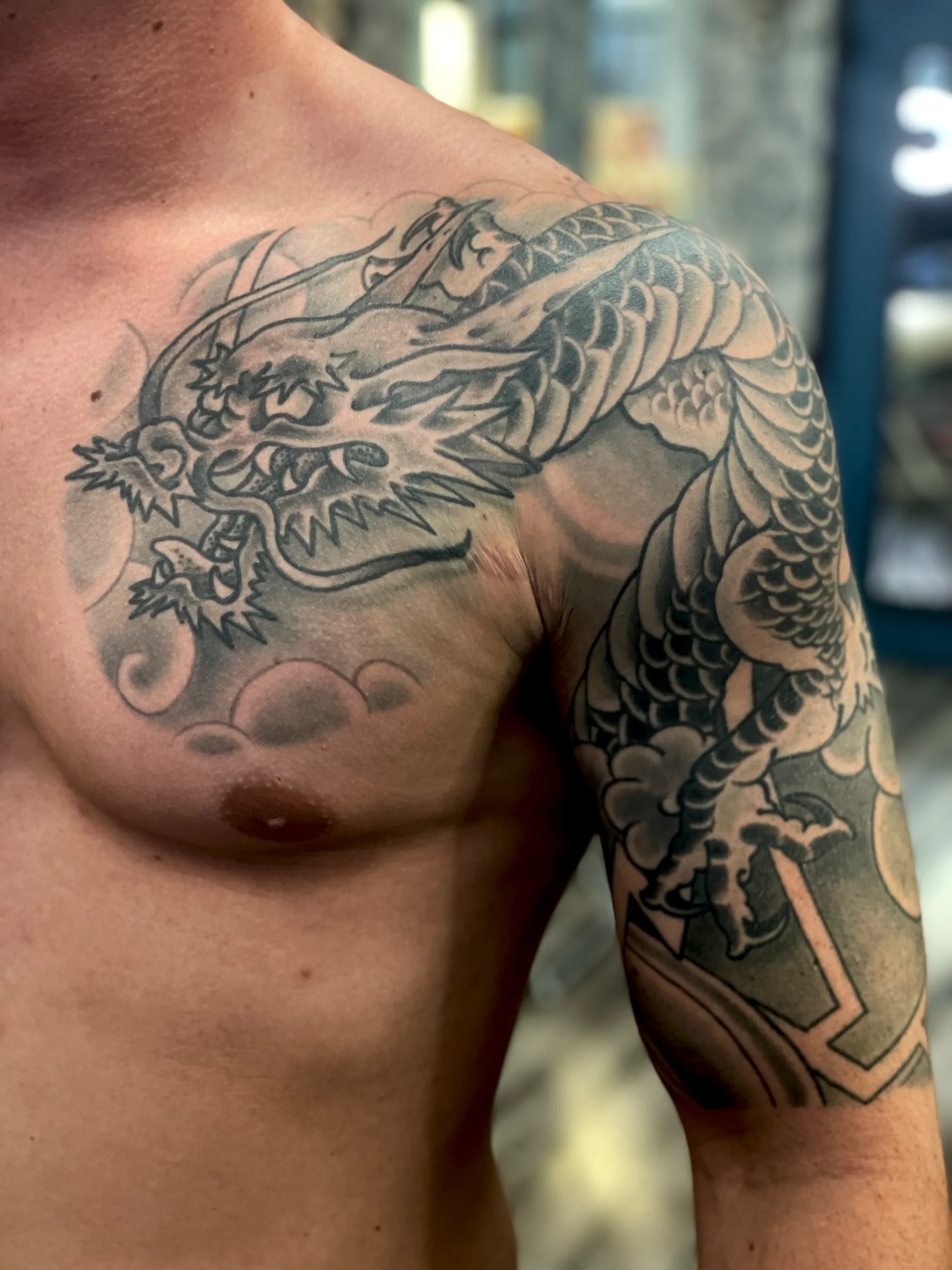 Dragon black and grey chest tattoo by Nate at Village Tattoo Company London Ontario