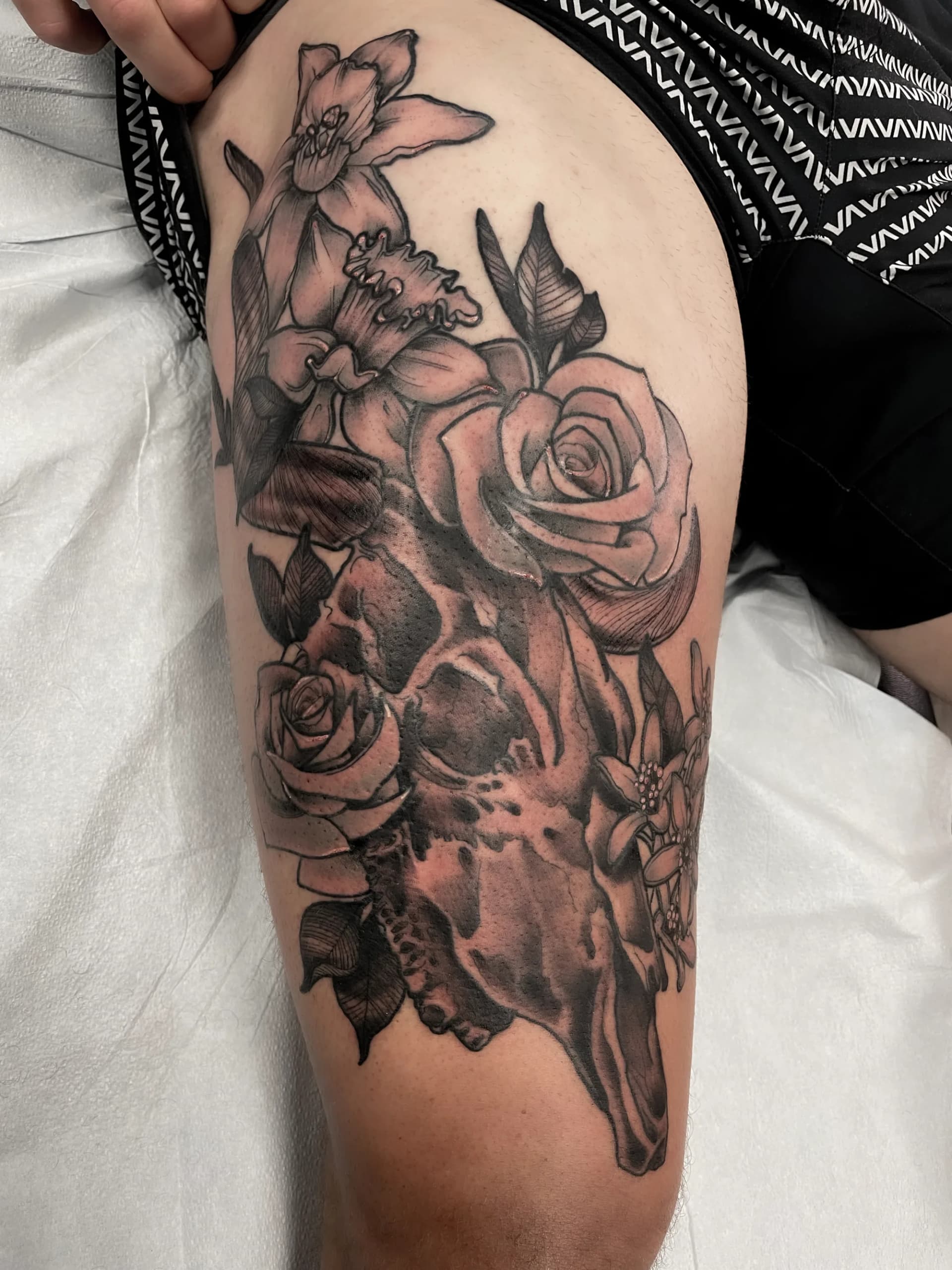 Cow skull with flowers black and grey tattoo by Nate at Village Tattoo Company London Ontario