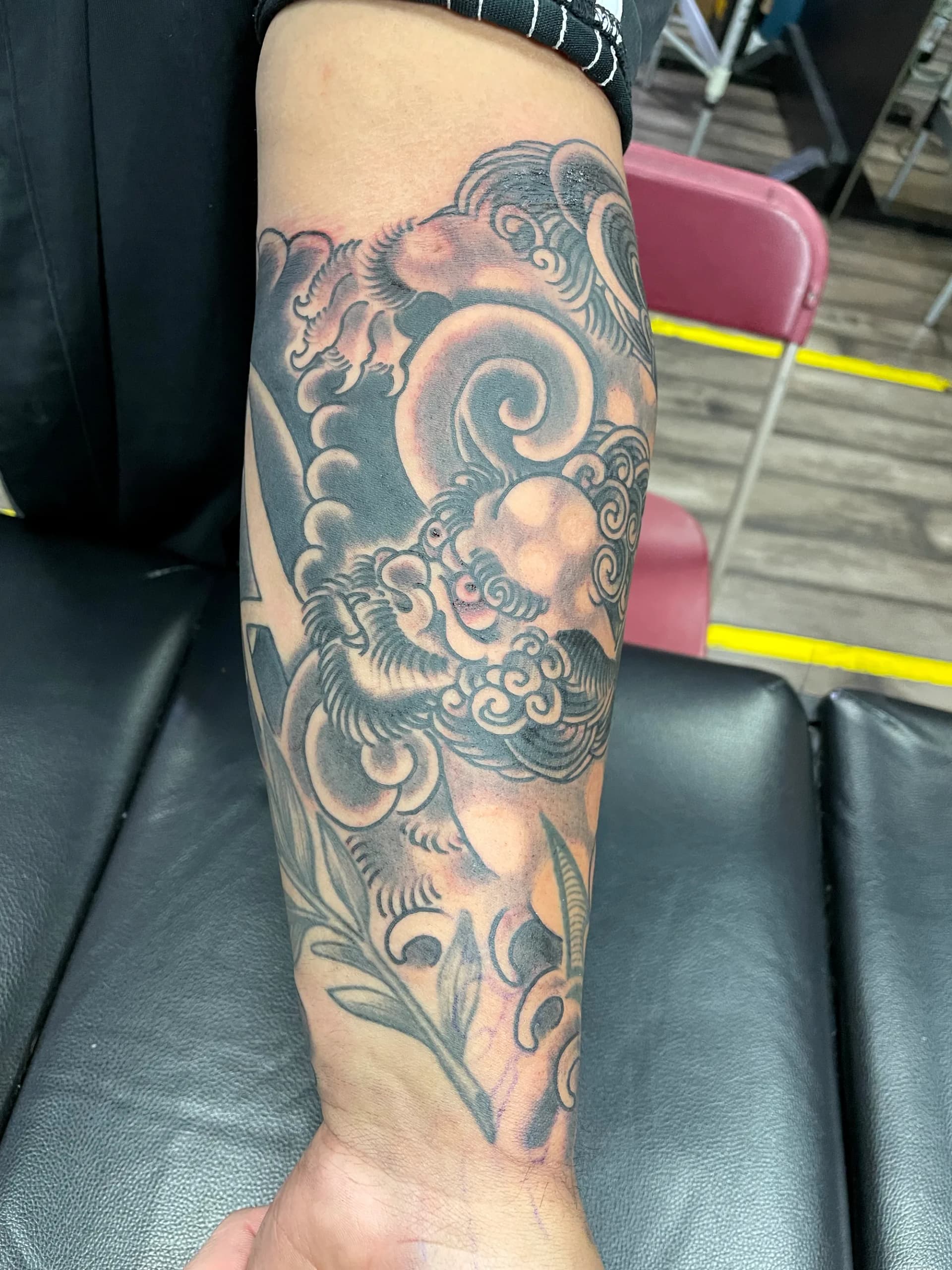 Foo dog black and grey forearm tattoo by Nate at Village Tattoo Company London Ontario