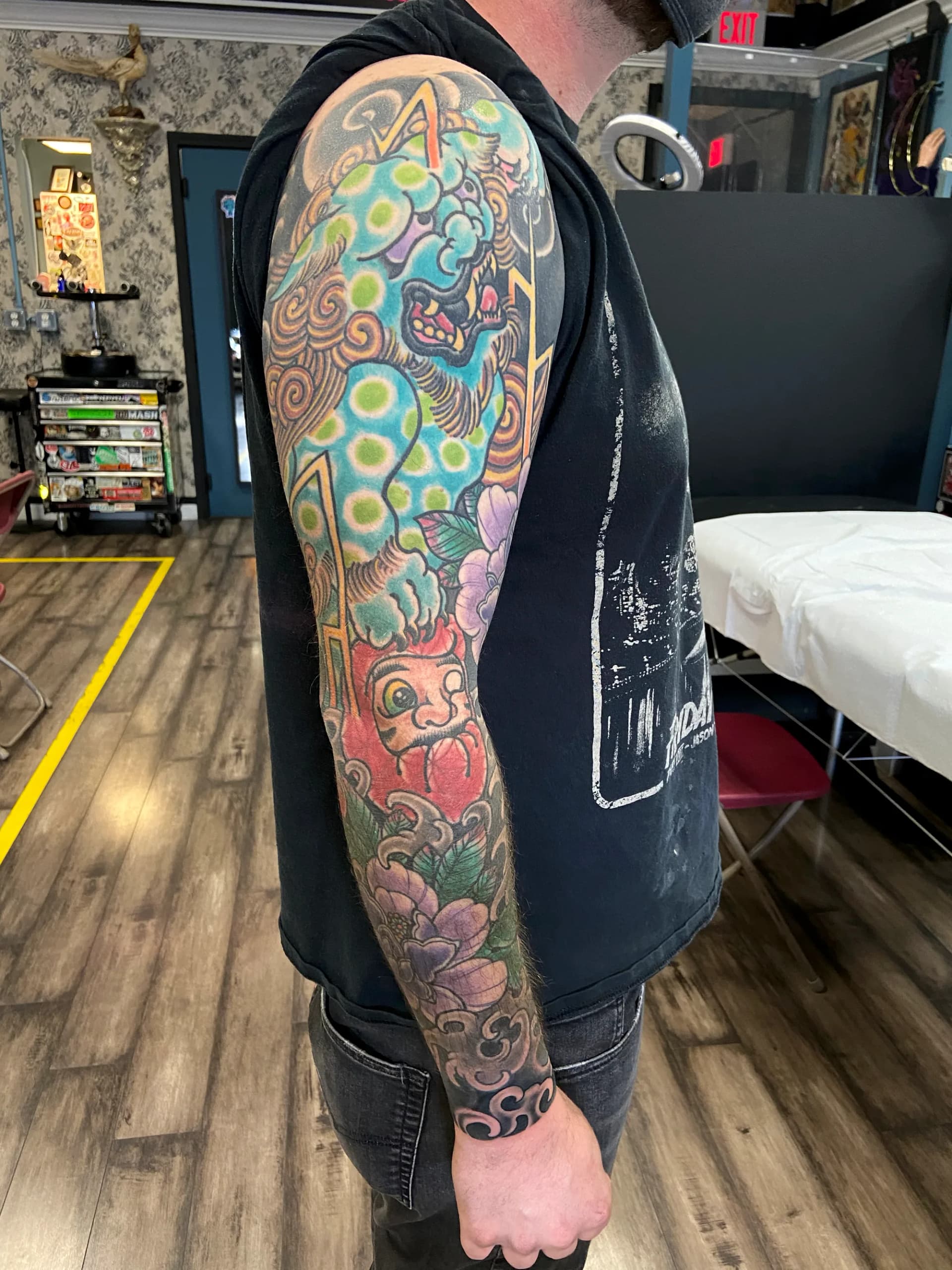 Foo dog and daruma Japanese colour full sleeve tattoo by Nate at Village Tattoo Company London Ontario