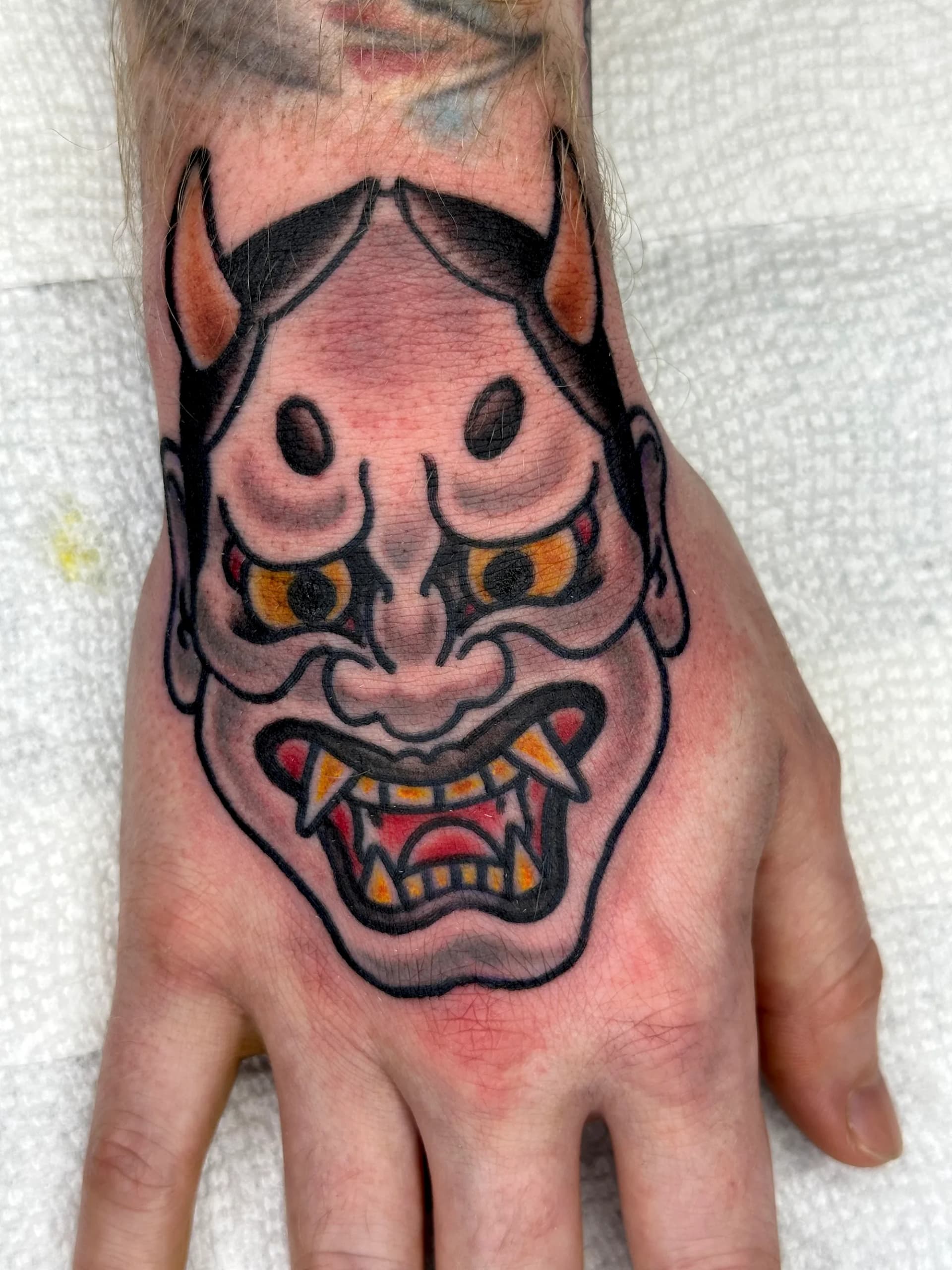Hannya mask hand tattoo by Nate at Village Tattoo Company London Ontario