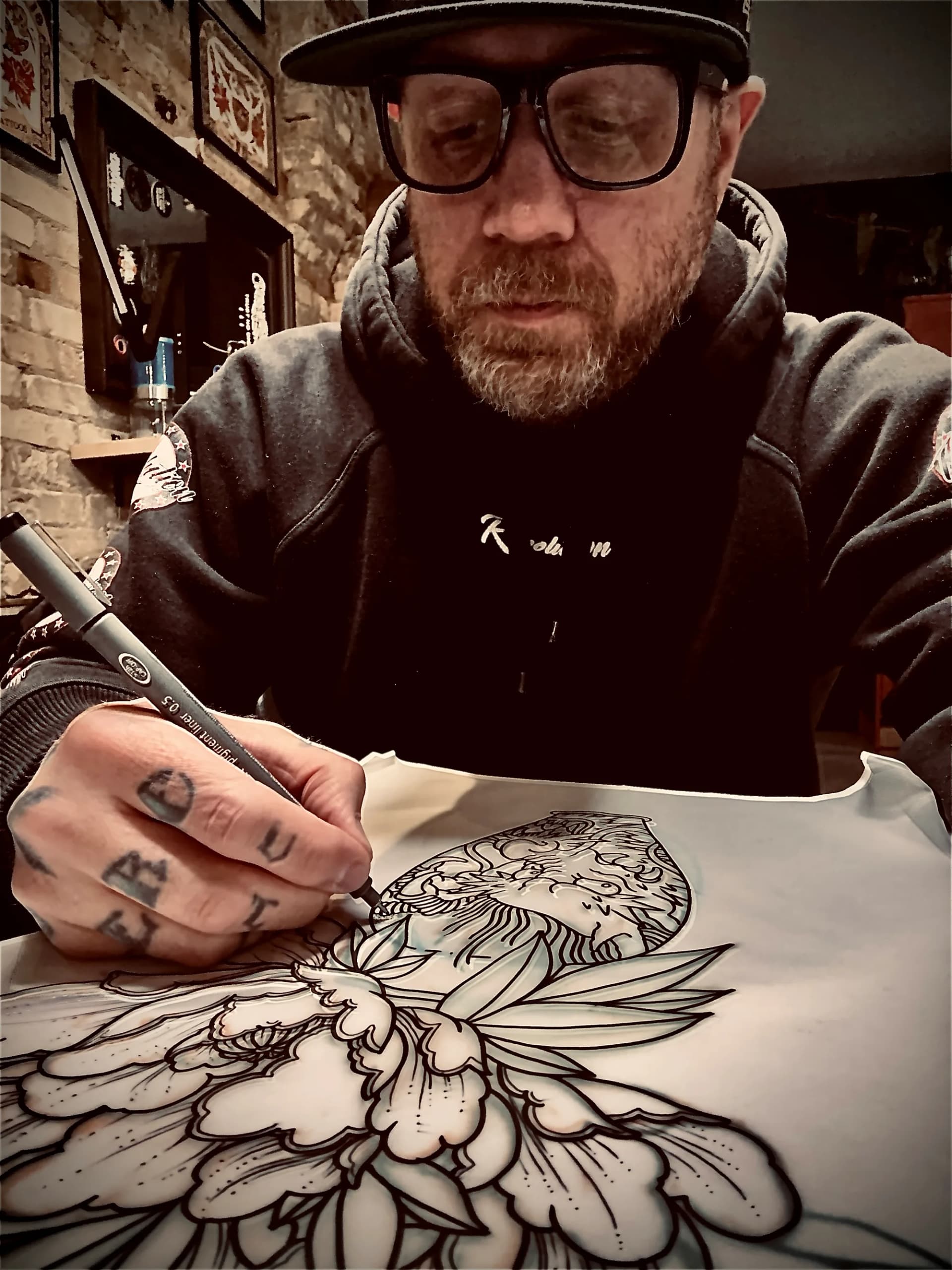 Nate drawing a Ganesha tattoo design at Village Tattoo Company London Ontario