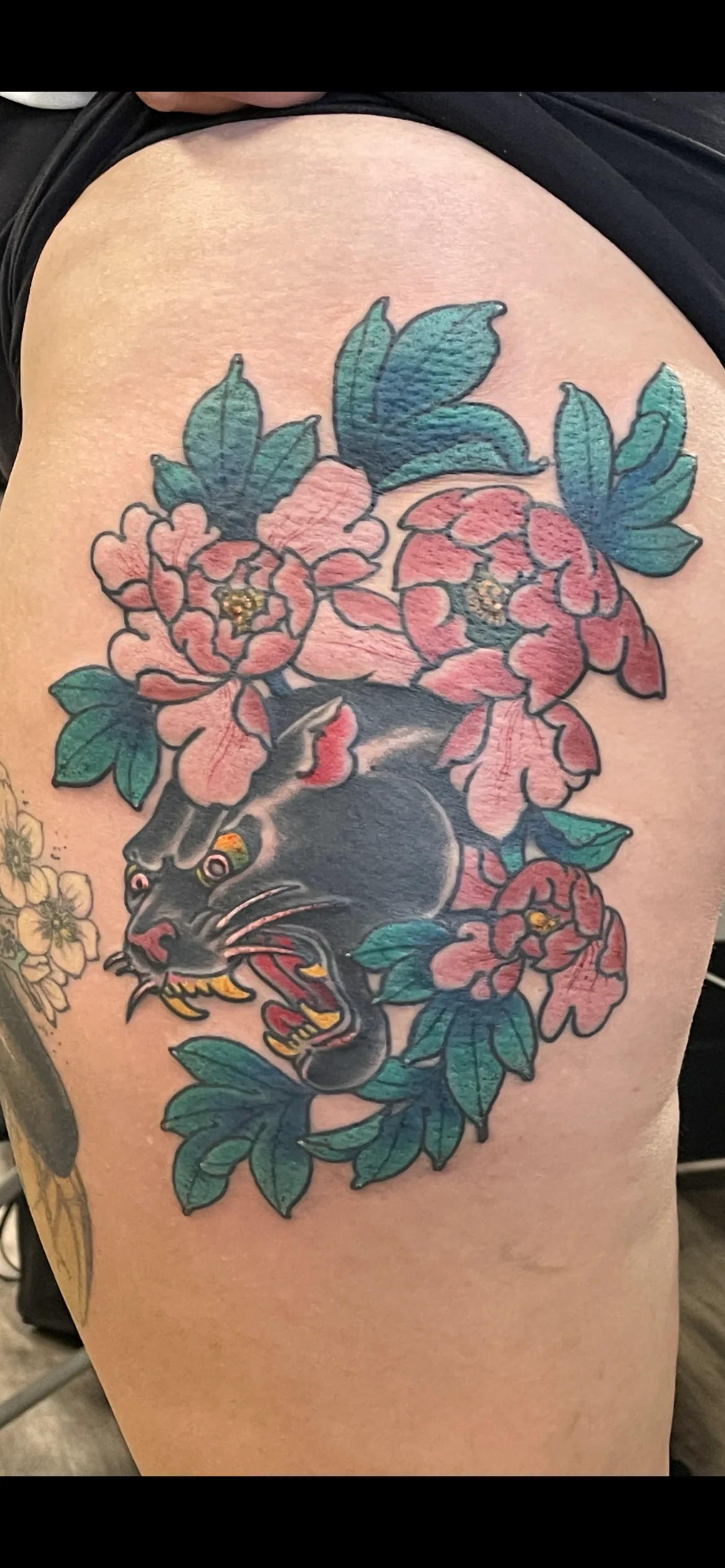 Panther with peonies traditional thigh tattoo by Nate at Village Tattoo Company London Ontario