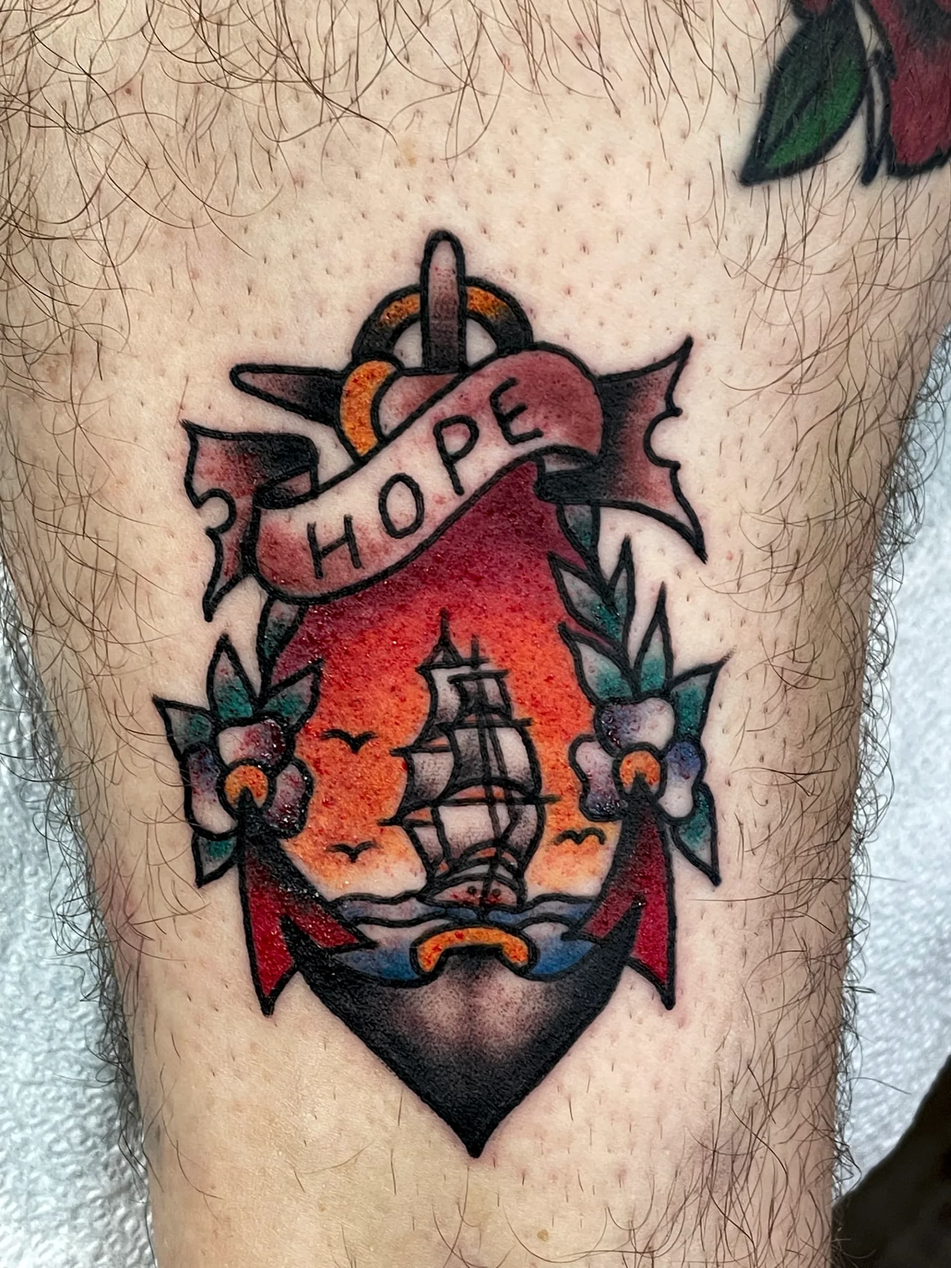 Traditional ship with anchor and hope banner ribs tattoo by Nate at Village Tattoo Company London Ontario