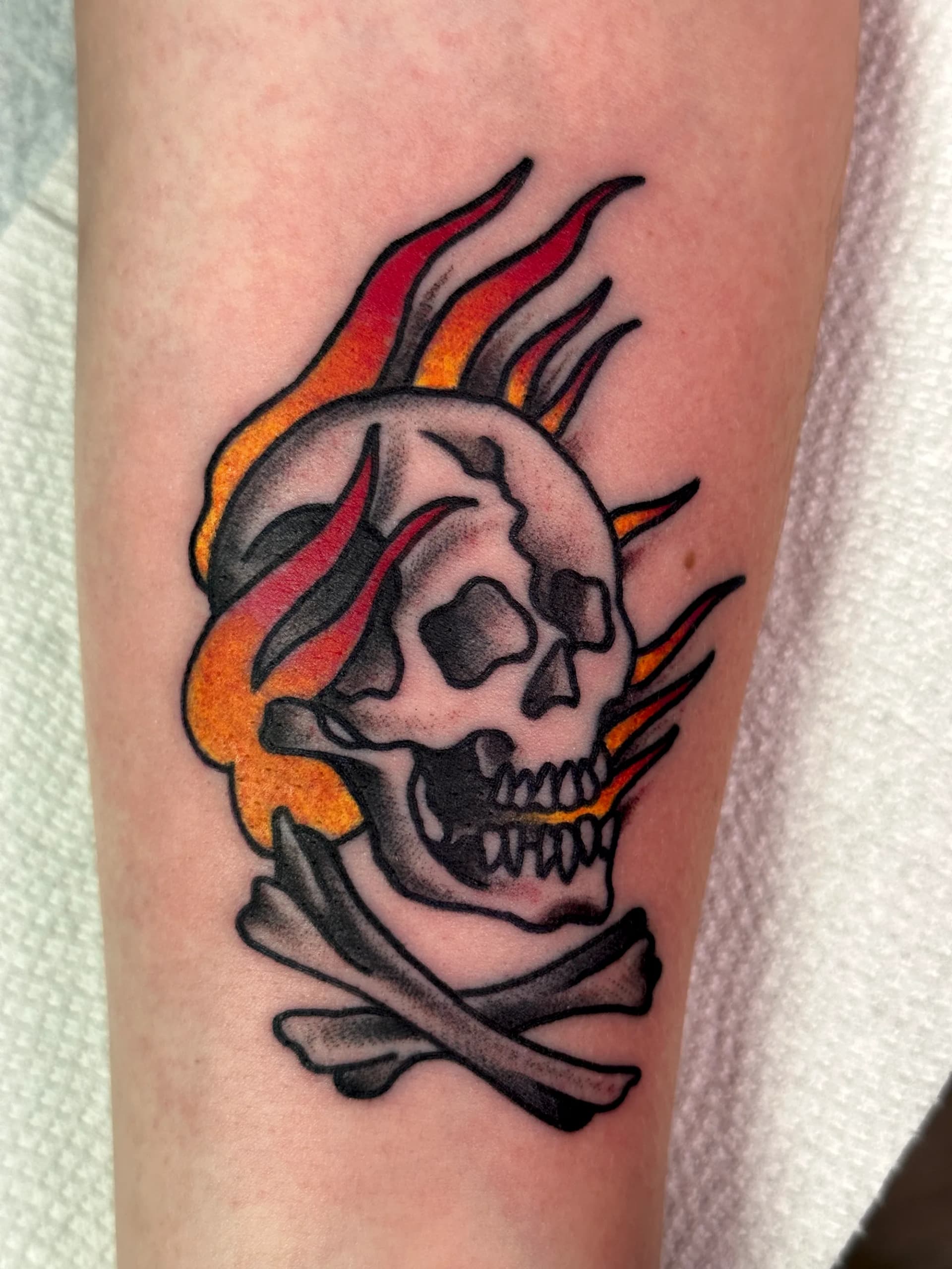 Skull with flames blackwork forearm tattoo by Nate at Village Tattoo Company London Ontario
